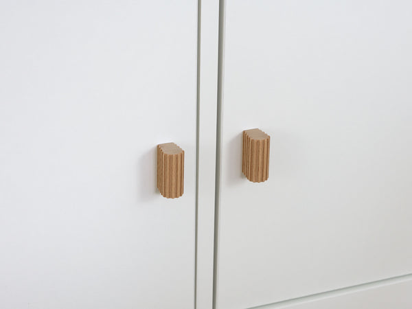 Wooden cabinet knobs on a white cabinet from ikea