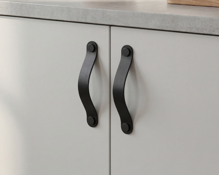 Close-up of black leather cabinet and drawer pull handle made from thick vegetable-tanned leather, 128 mm