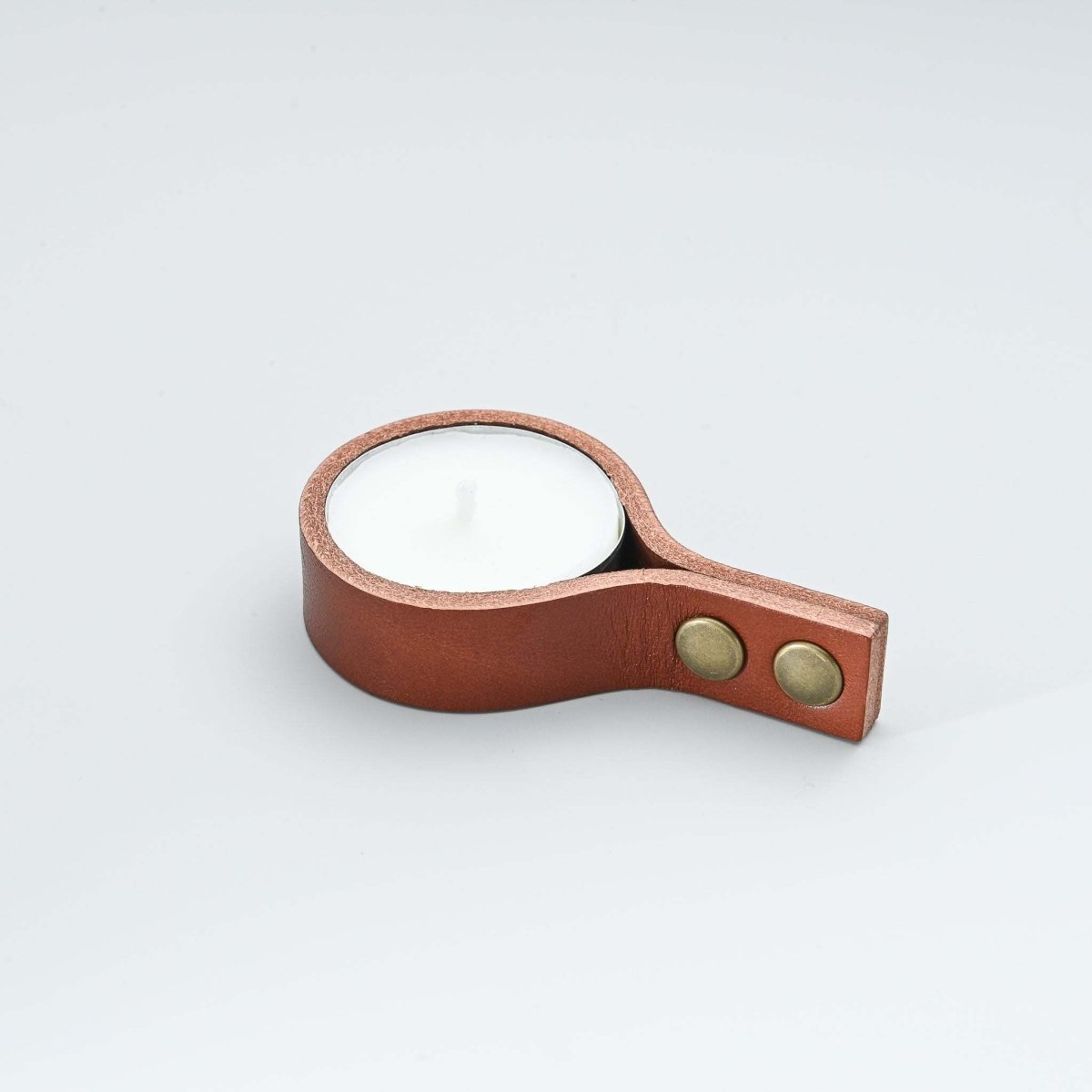Minimalist leather candle holder with straight ends and white tealight candle inside