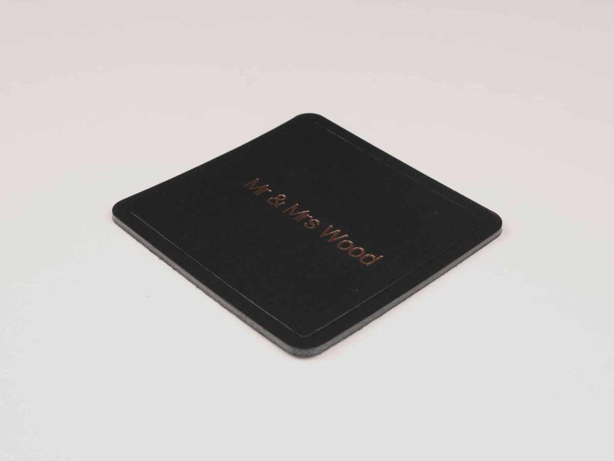 Square personalized leather coaster made from premium black Italian leather with engraved initials and resin backing